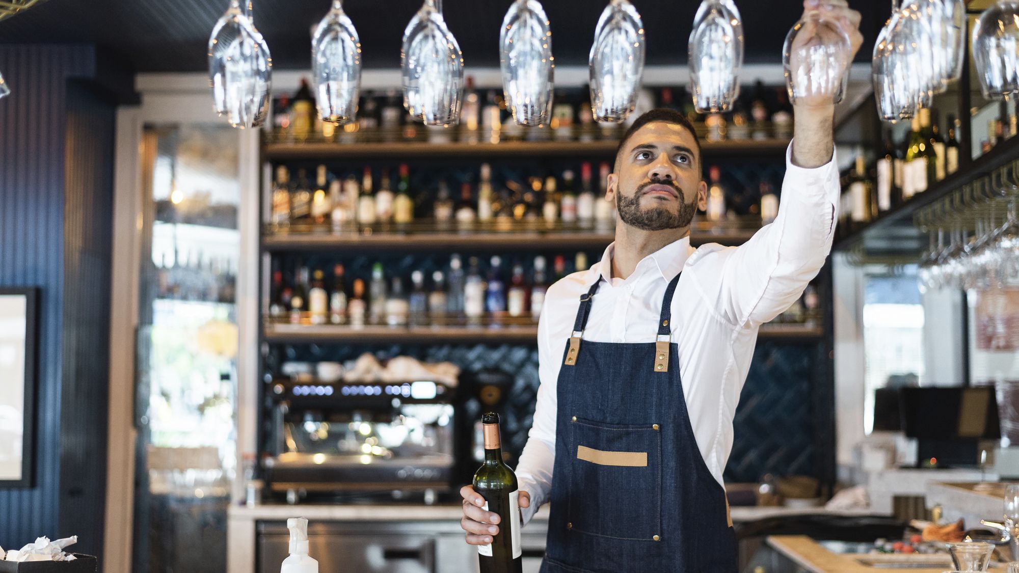 Bartender picking up a glass of wine