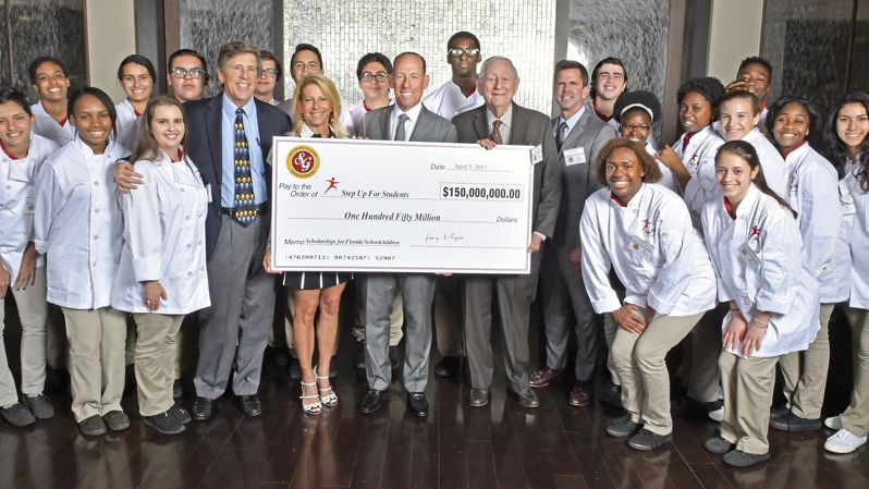 Southern Glazer's CEO Wayne E. Chaplin awarding large check to students.